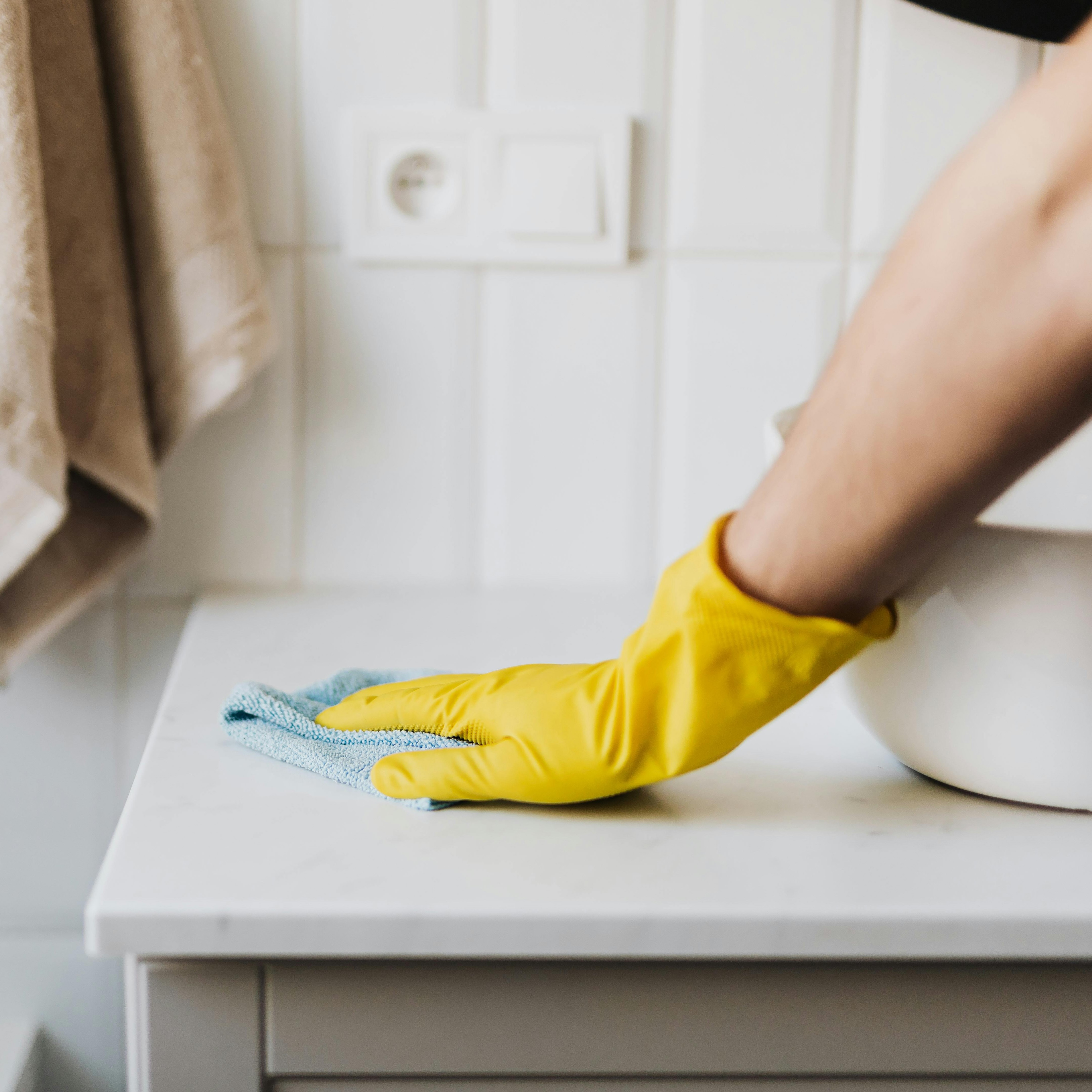 Hand wiping kitchen counter with cleaning cloth